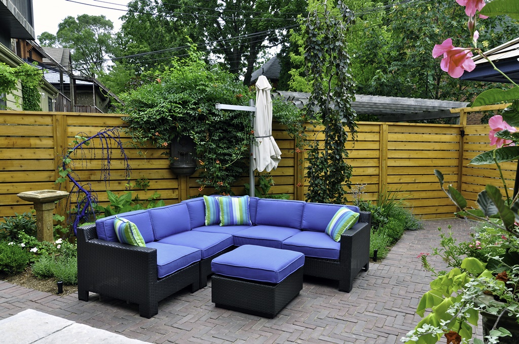 Relaxing patio furniture is seen in a beautiful urban backyard garden.