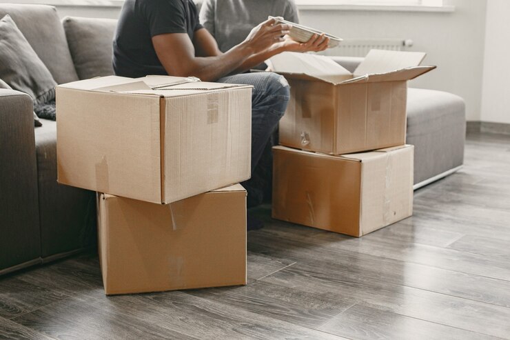 portrait-of-young-couple-with-cardboard-boxes-at-new-home-moving-house