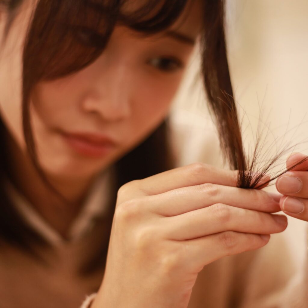 a lady checking the split ends on her hair